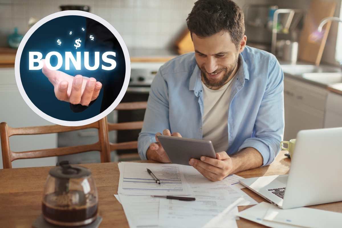 uomo seduto alla scrivania e scritta bonus in cornice