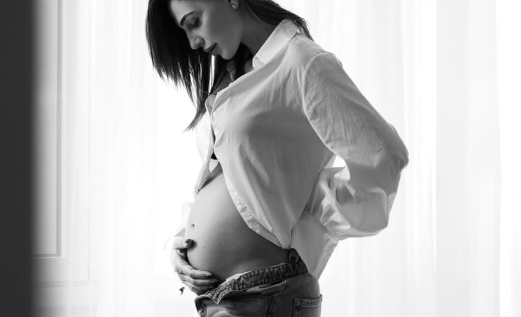 Anna Tatangelo che si guarda il pancione