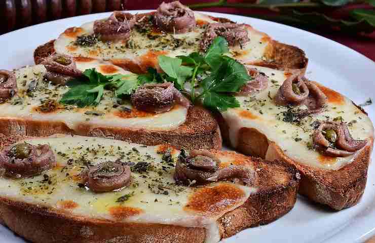 bruschette con formaggio fuso acciughe e capperi