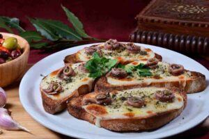 bruschetta cona acciughe formaggio fuso in un piatto