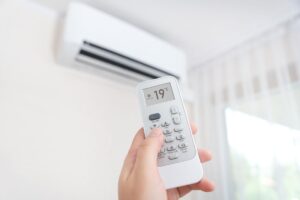 condizionatore sulla parete, mano con telecomando