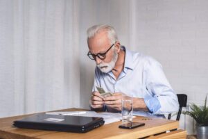 uomo seduto alla scrivania conta i soldi