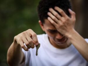 uomo disperato con chiave in mano
