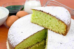 torta e fetta di torta a menta e cocco con zucchero a velo
